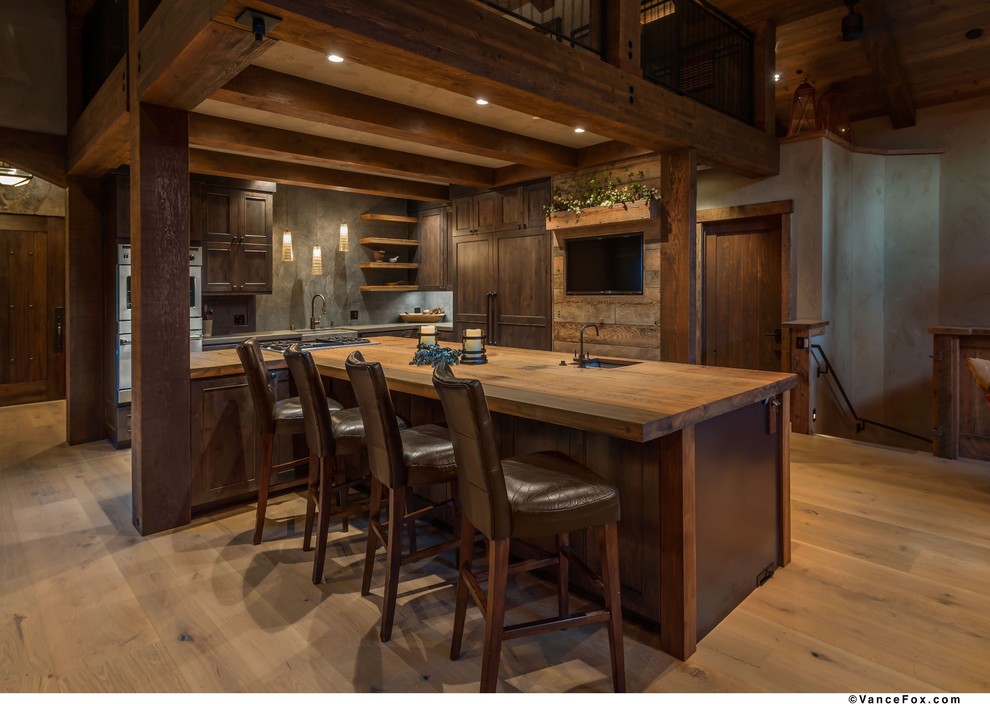 Mid-sized country kitchen in Other with an undermount sink, shaker cabinets, dark wood cabinets, stainless steel appliances, light hardwood floors and with island.
