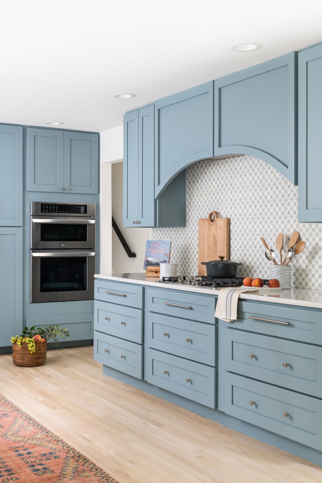 Example of a mid-sized transitional u-shaped eat-in kitchen design in Atlanta with an undermount sink, shaker cabinets, blue cabinets, blue backsplash and paneled appliances