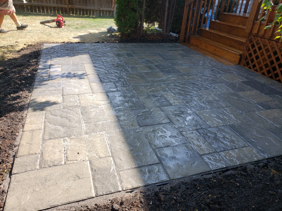 This is an example of a small rustic partial sun backyard concrete paver landscaping in Edmonton for summer.