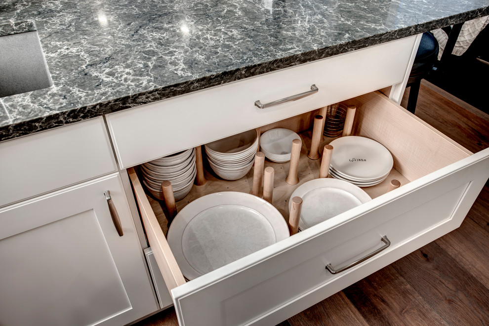 Inspiration for a mid-sized transitional l-shaped medium tone wood floor and brown floor eat-in kitchen remodel in Seattle with a double-bowl sink, shaker cabinets, white cabinets, quartz countertops, gray backsplash, ceramic backsplash, stainless steel appliances, two islands and gray countertops