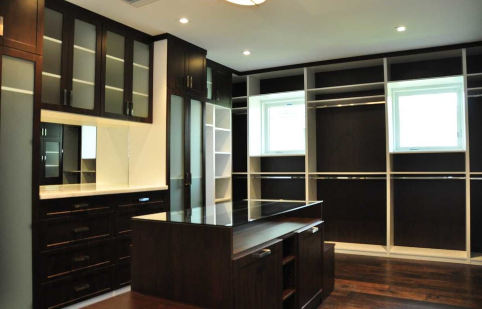 Design ideas for a mid-sized transitional gender-neutral walk-in wardrobe in Miami with shaker cabinets, dark wood cabinets, medium hardwood floors and brown floor.