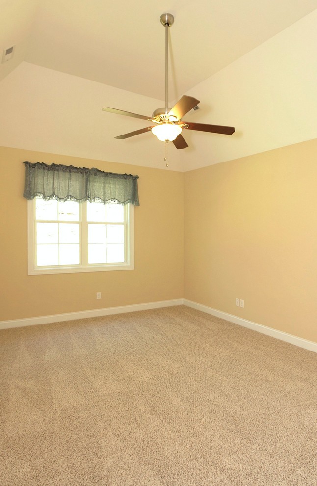 Design ideas for a mid-sized traditional master bedroom in Raleigh with beige walls and carpet.