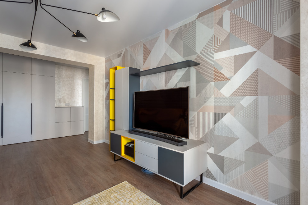 На фото: гостиная комната среднего размера в современном стиле с бежевыми стенами, полом из ламината, отдельно стоящим телевизором, зоной отдыха, коричневым полом, обоями на стенах и акцентной стеной