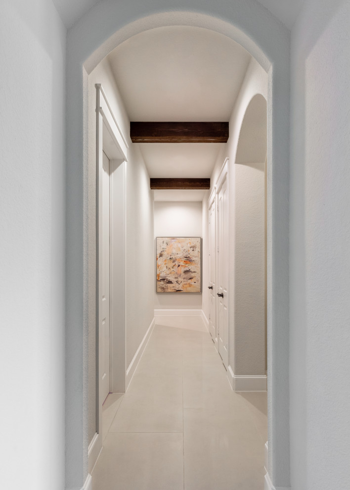Hallway - large mediterranean porcelain tile, beige floor and exposed beam hallway idea in Houston with white walls