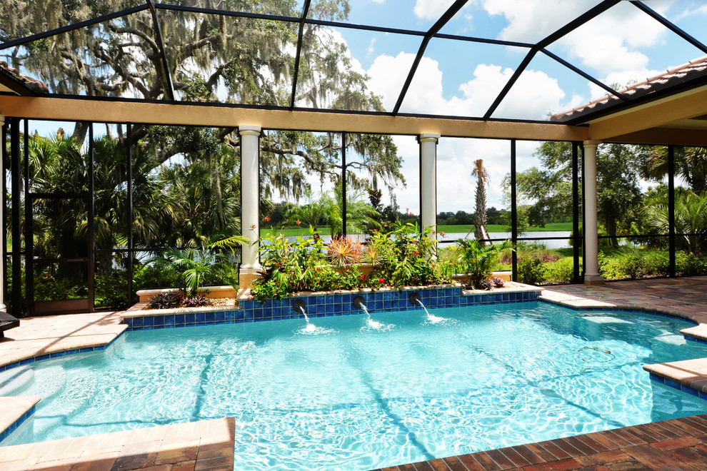 Inspiration for a traditional custom-shaped pool in Tampa with brick pavers.