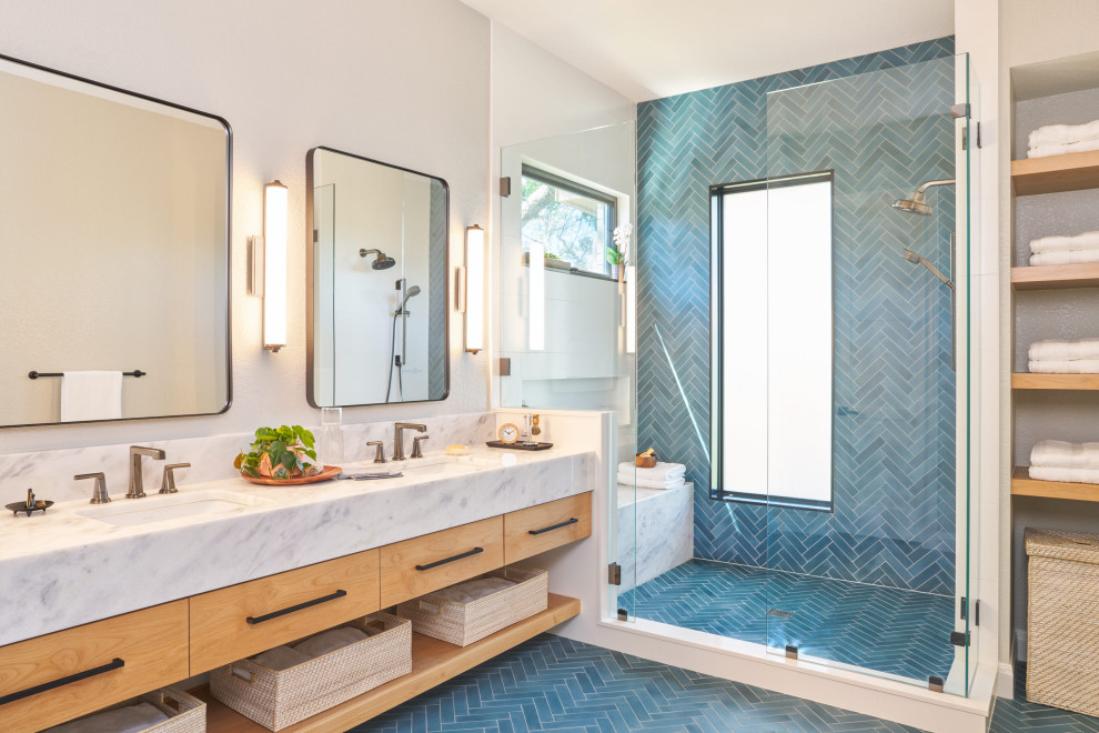 Пример оригинального дизайна: главная ванная комната среднего размера в современном стиле с плоскими фасадами, светлыми деревянными фасадами, синей плиткой, белыми стенами, врезной раковиной, мраморной столешницей, синим полом, сиденьем для душа, тумбой под две раковины и подвесной тумбой