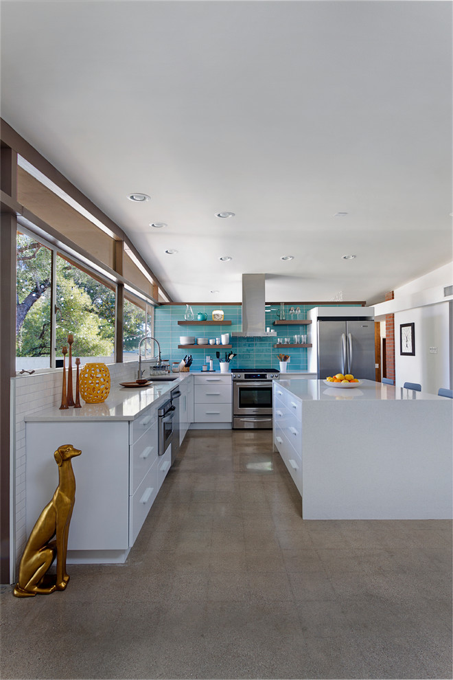 Photo of a mid-sized midcentury l-shaped eat-in kitchen in Phoenix with an undermount sink, flat-panel cabinets, white cabinets, quartz benchtops, blue splashback, glass tile splashback, stainless steel appliances, concrete floors and with island.