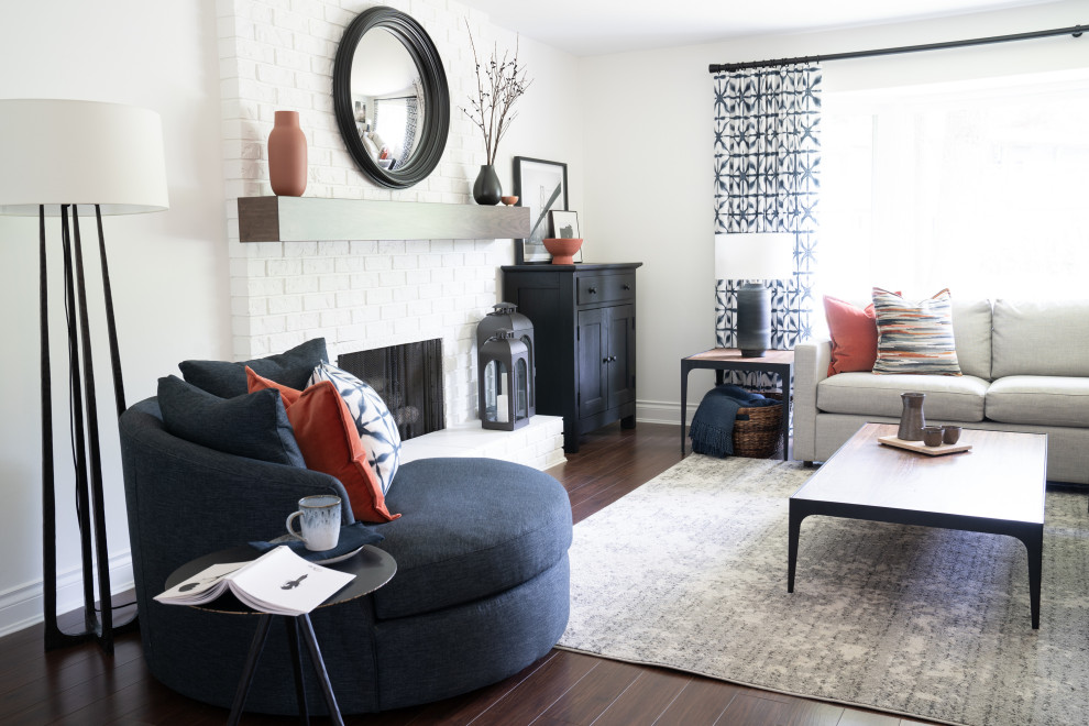 Mittelgroßes, Fernseherloses, Offenes Stilmix Wohnzimmer mit weißer Wandfarbe, braunem Holzboden, Kamin, Kaminumrandung aus Backstein und braunem Boden in Vancouver