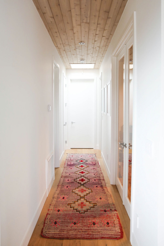 Idées déco pour un couloir scandinave avec un mur blanc, un sol en bois brun, un sol marron et un plafond en bois.