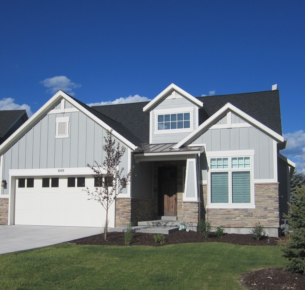 This is an example of a traditional three-storey blue exterior in Salt Lake City with stone veneer.