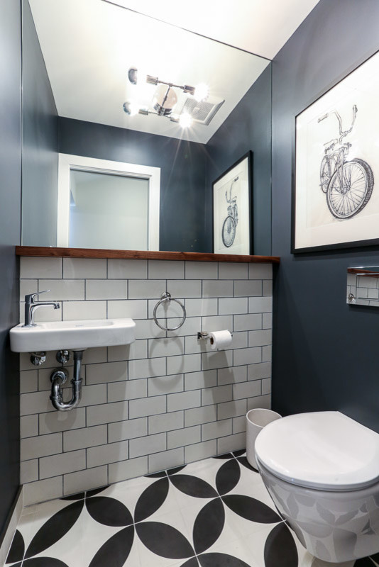 Photo of a small contemporary powder room in San Francisco with a wall-mount toilet, white tile, black and white tile, subway tile, grey walls, ceramic floors and a wall-mount sink.