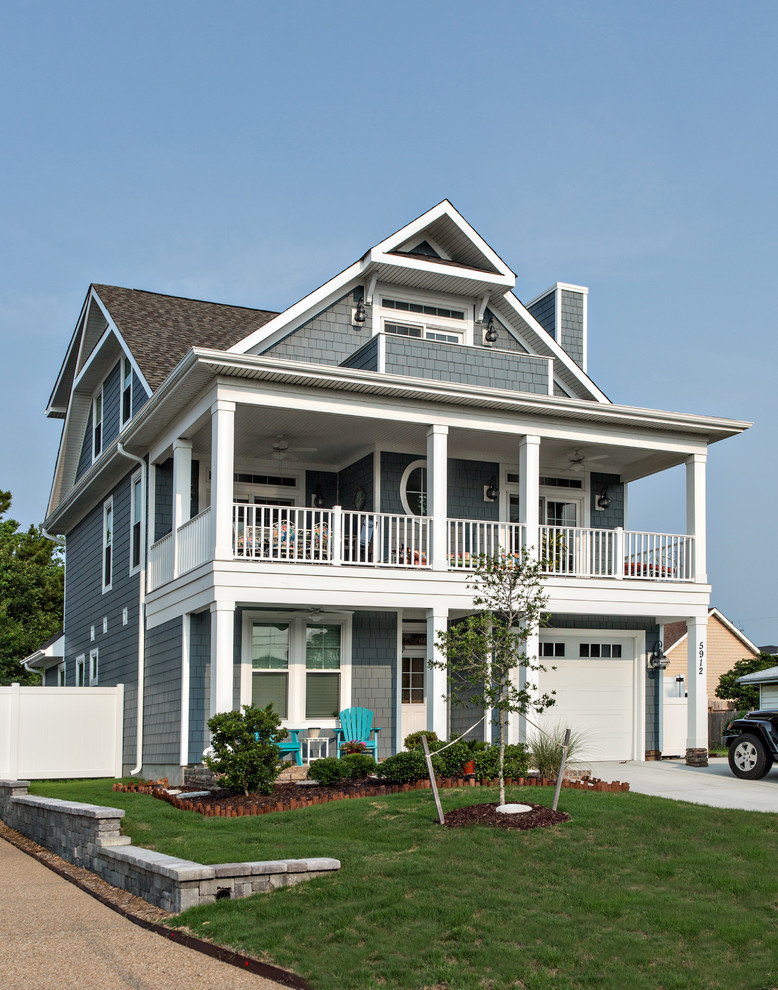 Design ideas for a mid-sized beach style three-storey grey exterior in Other with mixed siding and a gable roof.