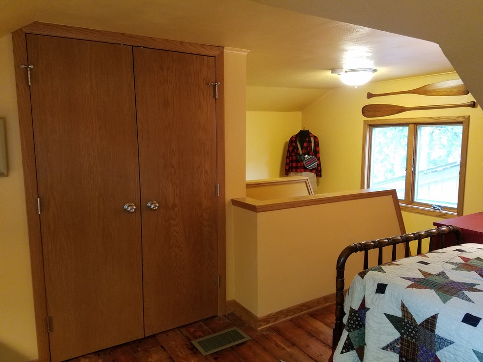Example of a small mountain style guest medium tone wood floor and beige floor home design design with yellow walls and no fireplace
