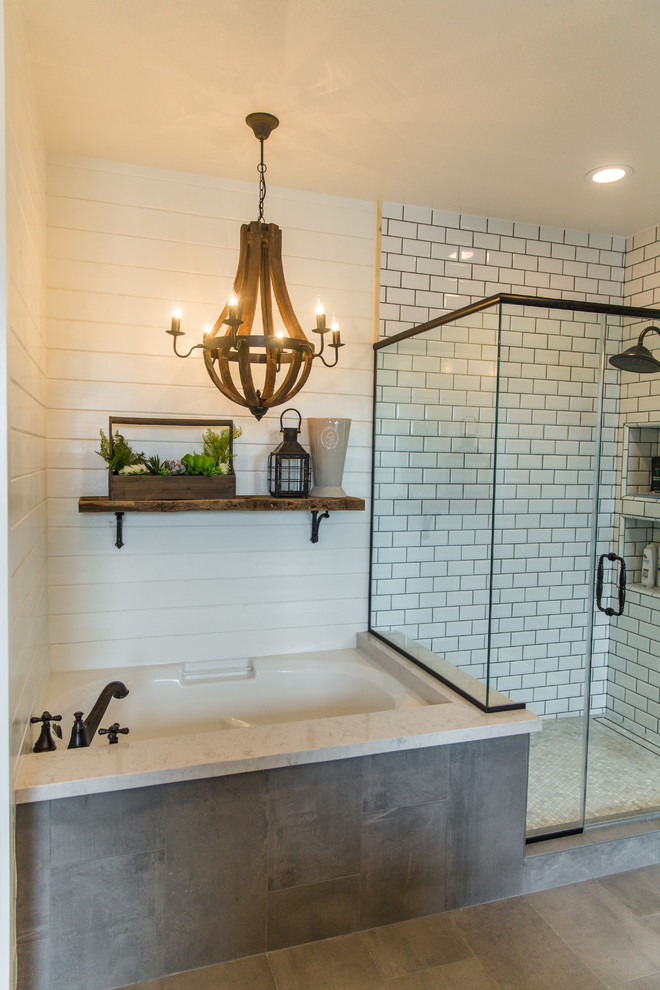 This is an example of a large country master bathroom in Los Angeles with shaker cabinets, white cabinets, a drop-in tub, a corner shower, a two-piece toilet, gray tile, ceramic tile, white walls, porcelain floors, a drop-in sink and solid surface benchtops.