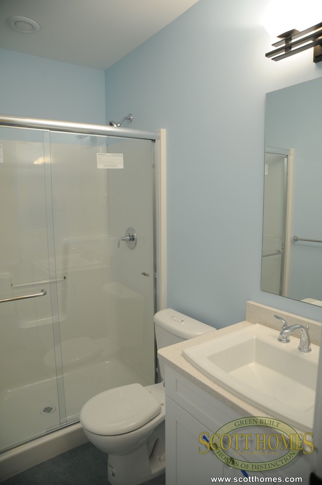 Mid-sized arts and crafts bathroom in Seattle with an integrated sink, recessed-panel cabinets, white cabinets, an alcove shower, a one-piece toilet, blue tile and white walls.