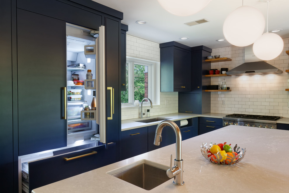 This is an example of a midcentury kitchen in Cincinnati with an undermount sink, flat-panel cabinets, blue cabinets, white splashback, cork floors and with island.