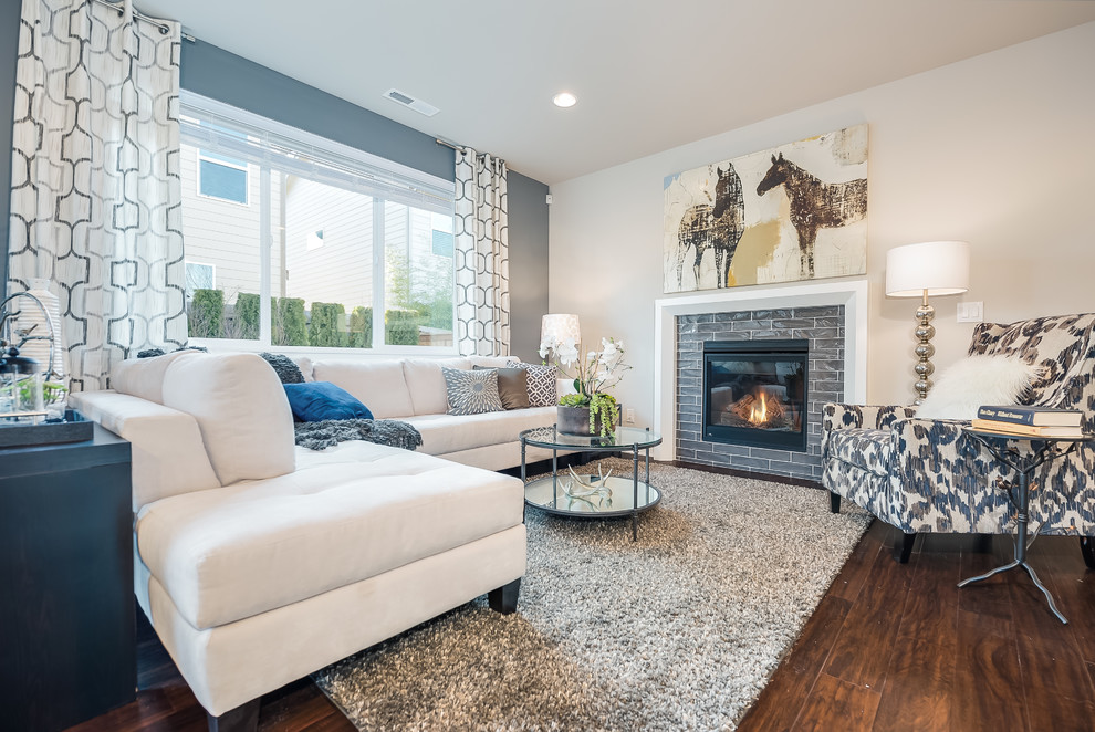 This is an example of a transitional living room in Seattle with grey walls, medium hardwood floors, a standard fireplace and no tv.