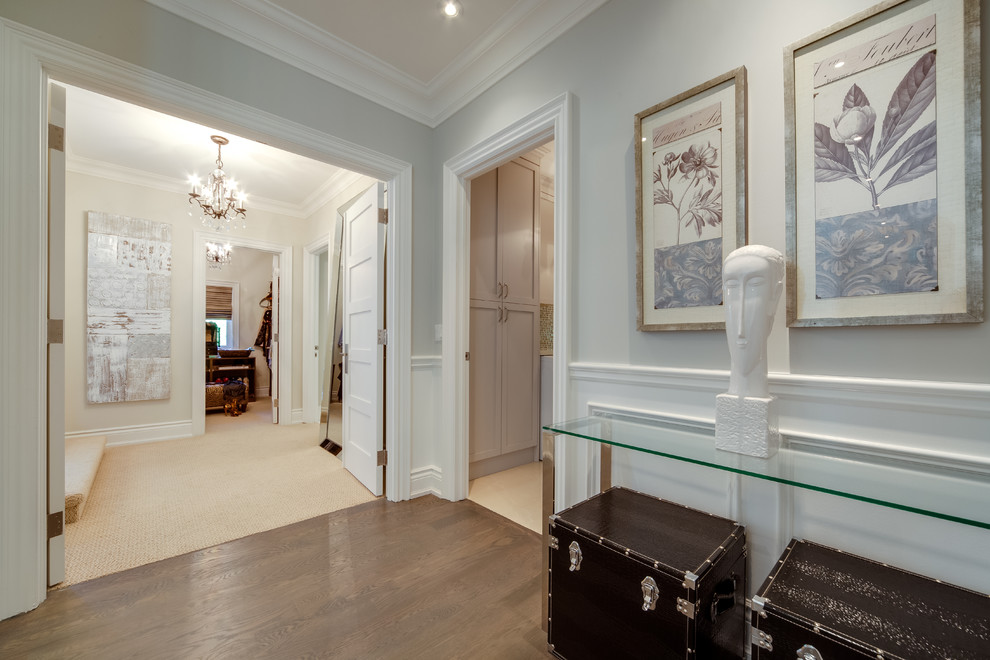 This is an example of a mid-sized contemporary hallway in Toronto with brown walls, dark hardwood floors and beige floor.