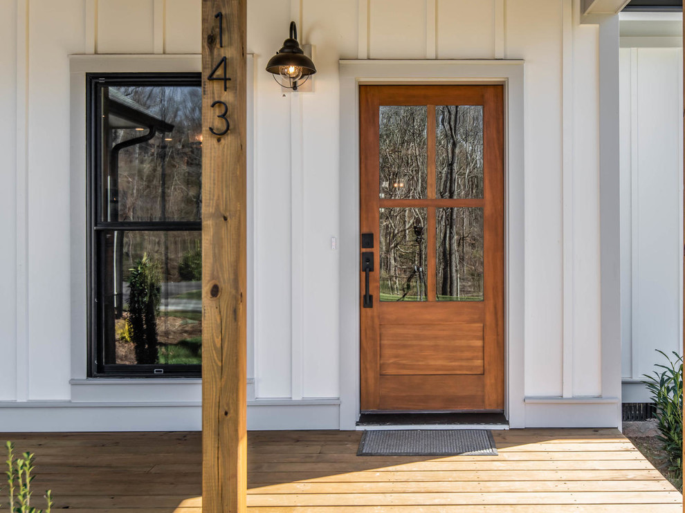 Photo of a mid-sized country front door in Other with white walls, a single front door and a medium wood front door.
