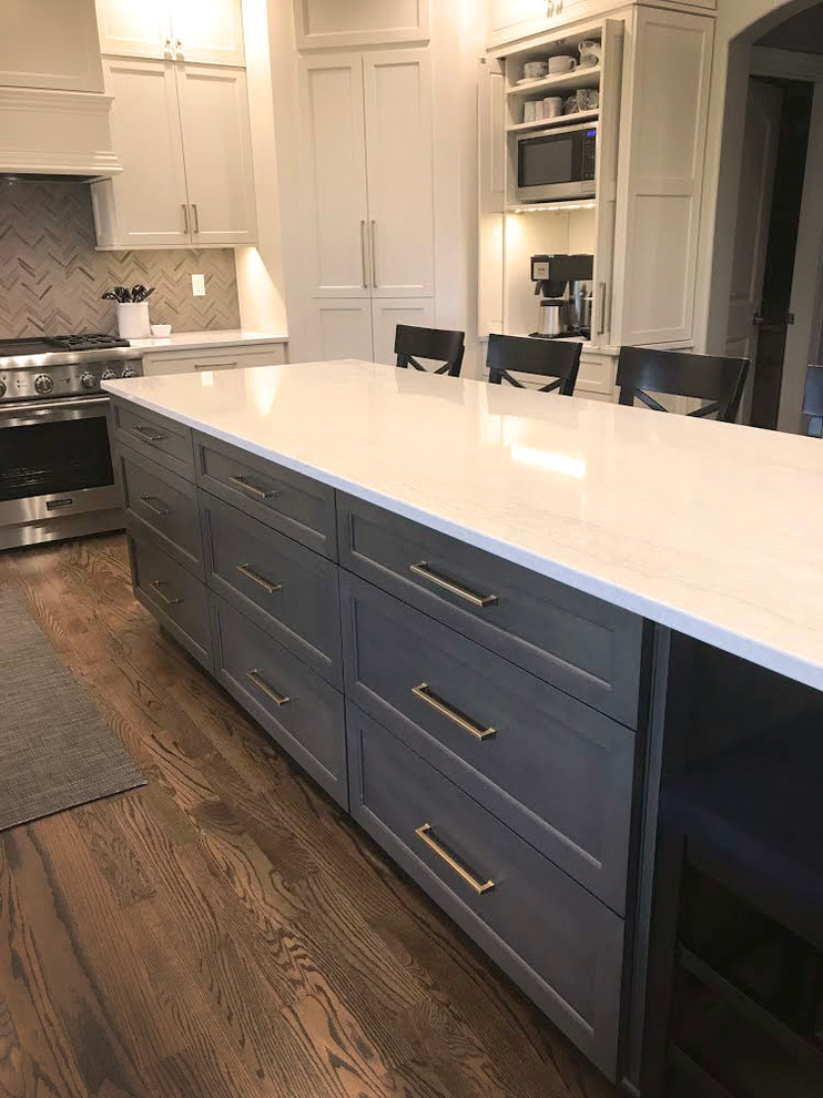 Example of a transitional kitchen design with flat-panel cabinets, gray cabinets, quartz countertops, gray backsplash and white countertops
