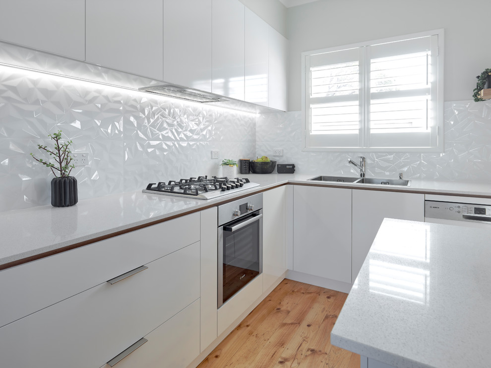 Inspiration for a large contemporary l-shaped kitchen in Other with a double-bowl sink, white cabinets, quartz benchtops, white splashback, ceramic splashback, stainless steel appliances, medium hardwood floors and with island.