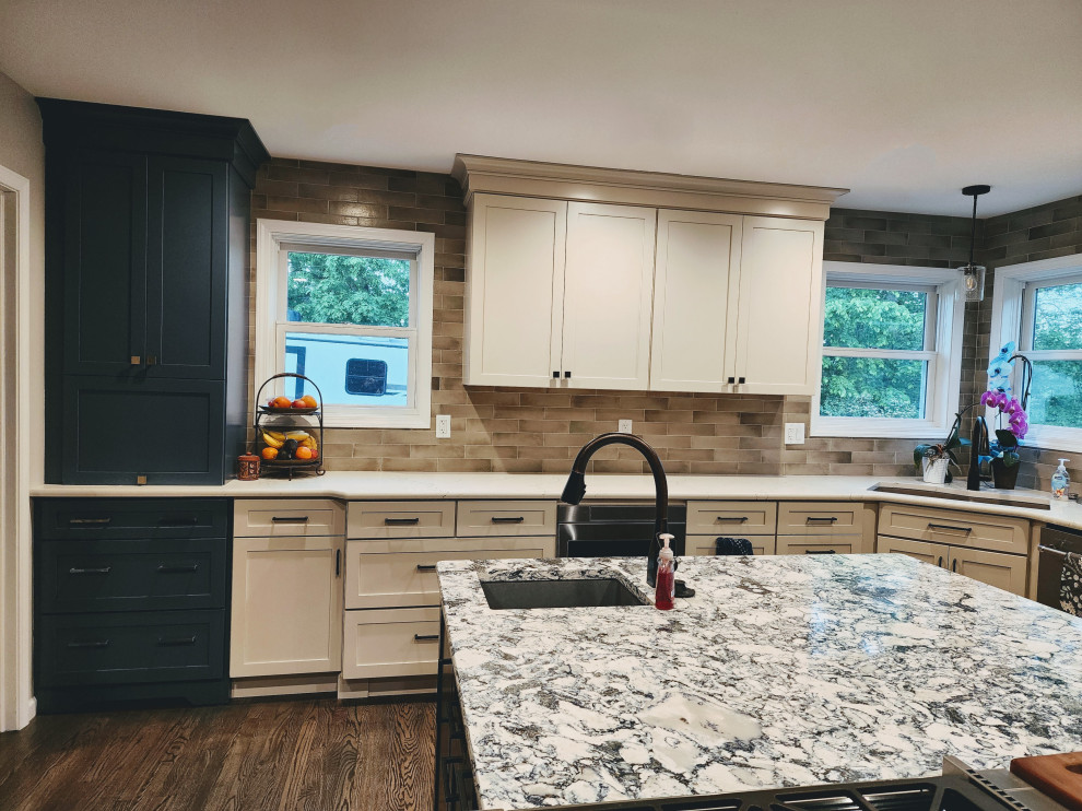 Eat-in kitchen - large farmhouse l-shaped medium tone wood floor and gray floor eat-in kitchen idea with an undermount sink, shaker cabinets, subway tile backsplash, stainless steel appliances, an island and multicolored countertops