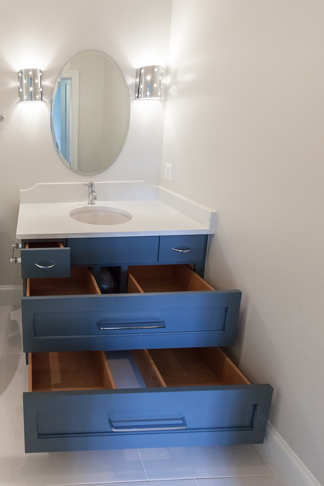 Traditional kids bathroom in DC Metro with shaker cabinets, blue cabinets, an alcove shower, a two-piece toilet, white tile, beige walls, an undermount sink, beige floor, a hinged shower door and white benchtops.