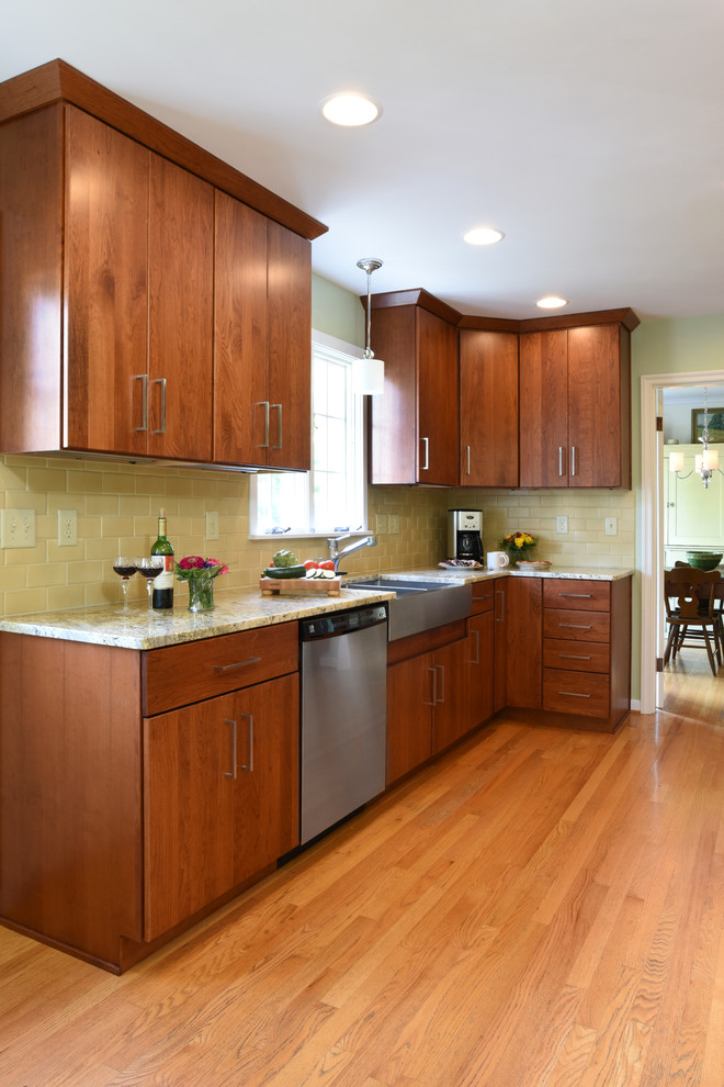 Example of a mid-sized transitional galley light wood floor enclosed kitchen design with a farmhouse sink, flat-panel cabinets, medium tone wood cabinets, granite countertops, yellow backsplash, ceramic backsplash, stainless steel appliances and no island
