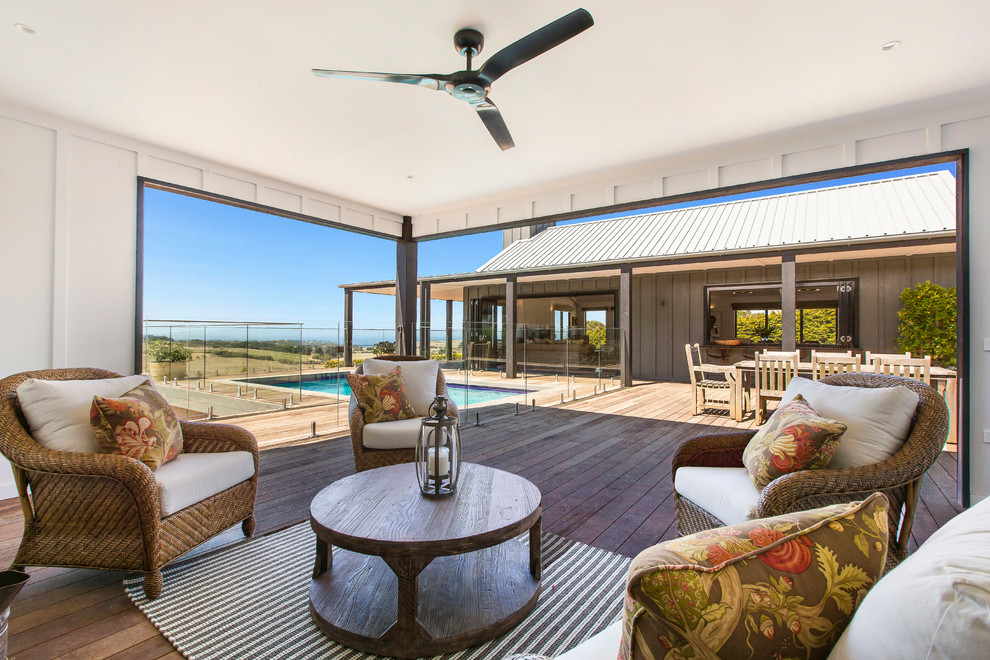 This is an example of a large beach style deck in Melbourne with a roof extension.