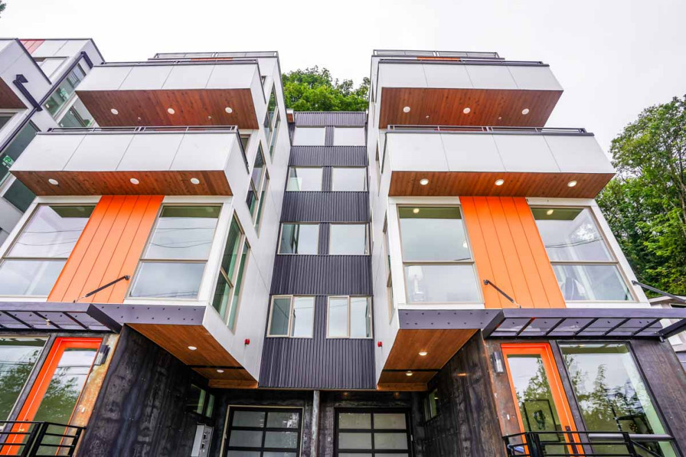 シアトルにある巨大なコンテンポラリースタイルのおしゃれな家の外観 (混合材サイディング、マルチカラーの外壁、タウンハウス、混合材屋根、縦張り) の写真