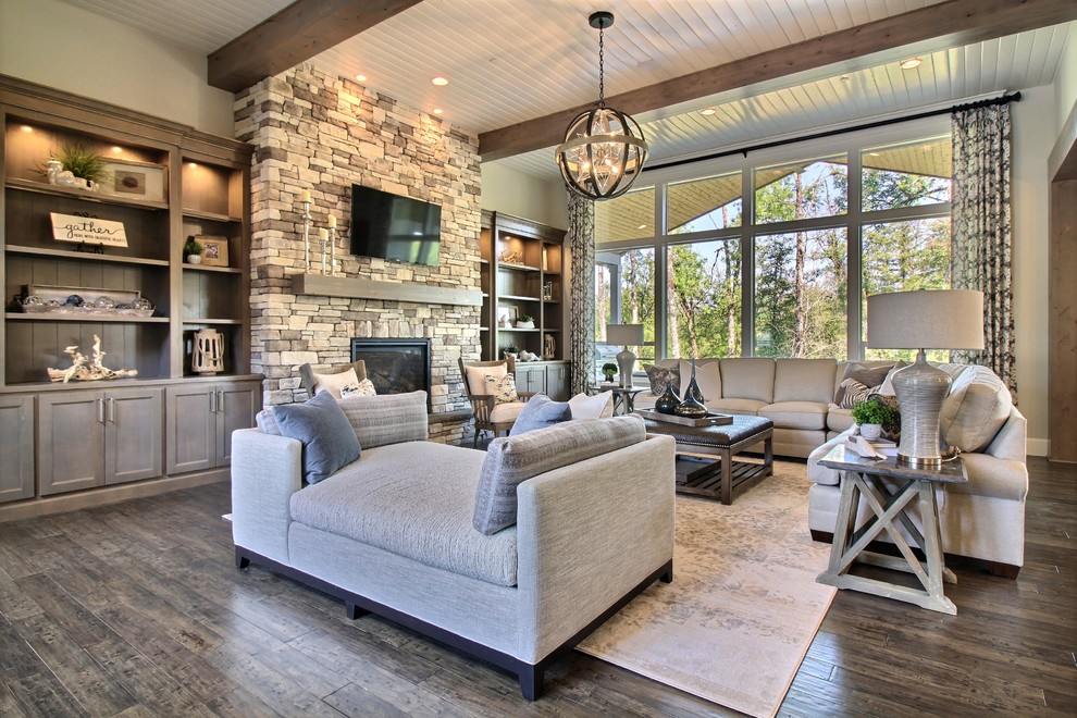 Photo of an expansive arts and crafts open concept family room in Portland with beige walls, dark hardwood floors, a standard fireplace, a stone fireplace surround, brown floor and a wall-mounted tv.