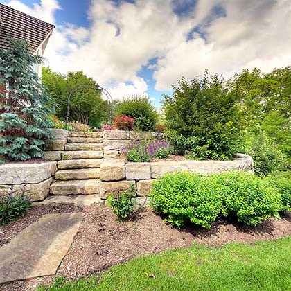 Photo of a large country backyard full sun formal garden for summer in Kansas City with a garden path and natural stone pavers.
