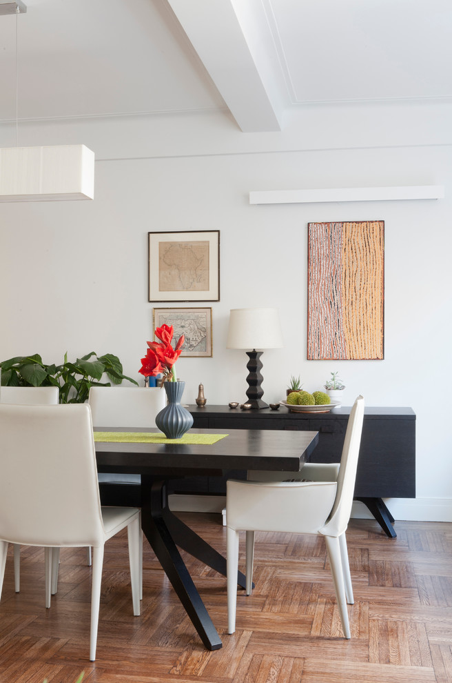 This is an example of a mid-sized contemporary dining room in New York with white walls, medium hardwood floors and no fireplace.
