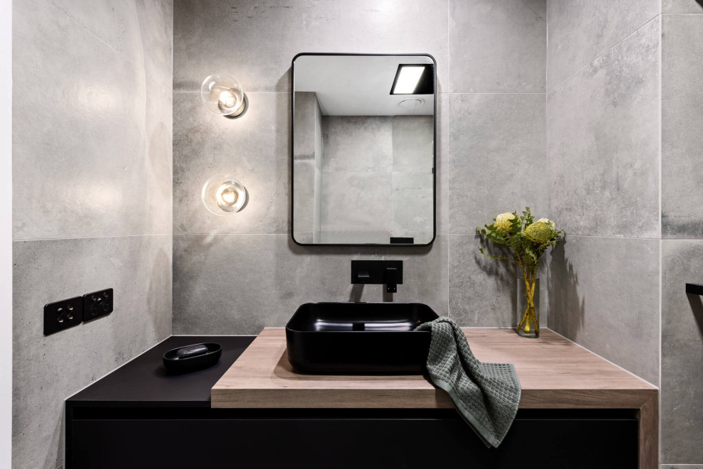 Photo of a mid-sized contemporary master bathroom in Melbourne with a floating vanity, shaker cabinets, black cabinets, an open shower, a one-piece toilet, gray tile, cement tile, grey walls, cement tiles, a vessel sink, laminate benchtops, grey floor, an open shower, brown benchtops and a single vanity.