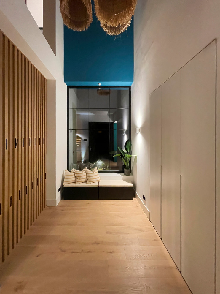 Стильный дизайн: коридор среднего размера: освещение в морском стиле с синими стенами, паркетным полом среднего тона, коричневым полом и панелями на стенах - последний тренд