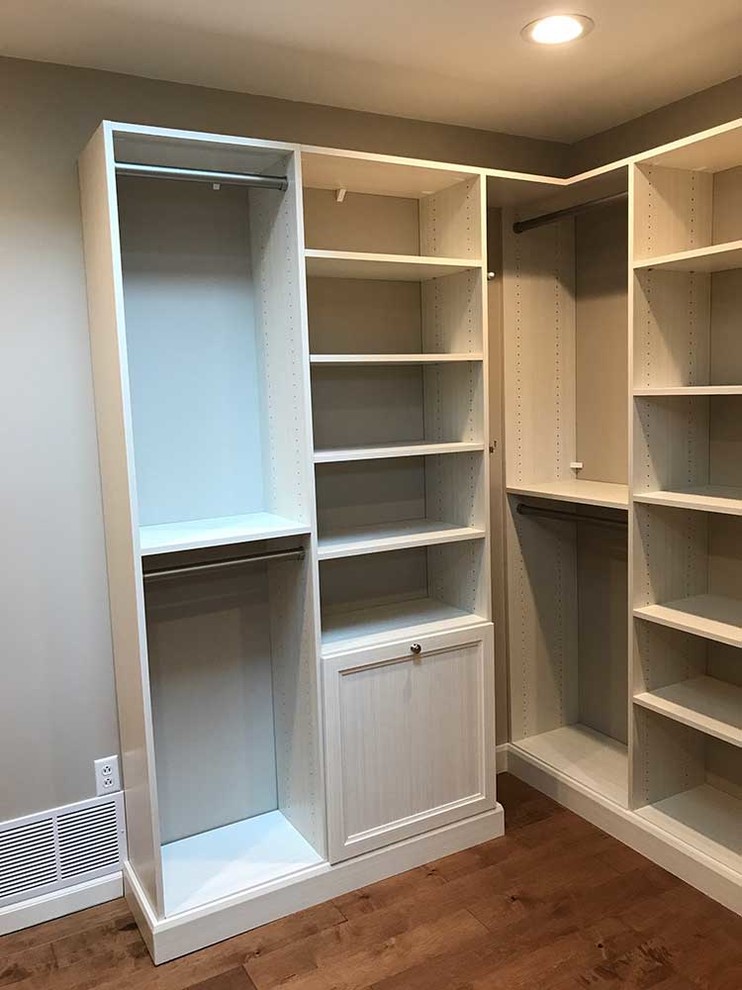 Design ideas for a mid-sized transitional gender-neutral dressing room in Other with recessed-panel cabinets, light wood cabinets and medium hardwood floors.