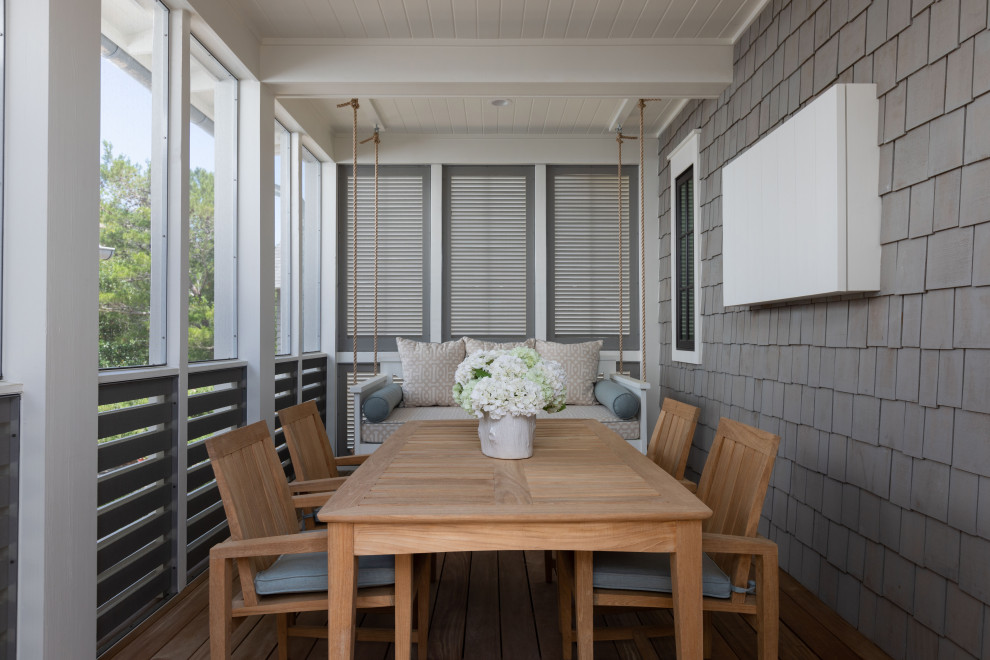 Inspiration pour un porche d'entrée de maison arrière marin de taille moyenne avec une moustiquaire, une terrasse en bois, une extension de toiture et un garde-corps en bois.