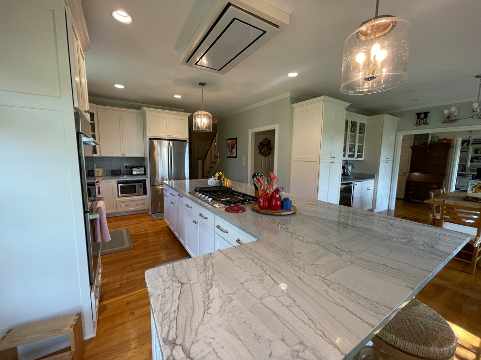 Inspiration for a large transitional light wood floor and brown floor eat-in kitchen remodel with an undermount sink, shaker cabinets, white cabinets, quartzite countertops, green backsplash, marble backsplash, stainless steel appliances, an island and gray countertops