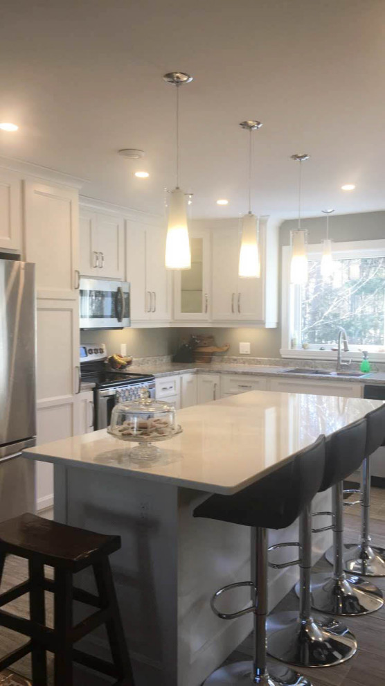 Inspiration for a mid-sized transitional u-shaped porcelain tile and gray floor eat-in kitchen remodel with an undermount sink, recessed-panel cabinets, white cabinets, quartz countertops, stainless steel appliances, an island and white countertops