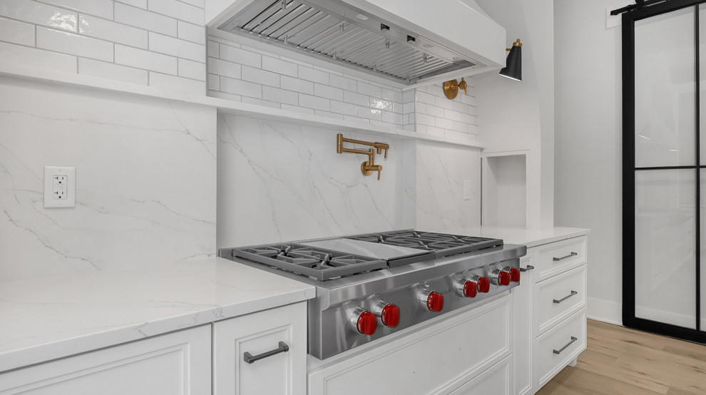Example of a transitional kitchen design in Columbus with white backsplash, subway tile backsplash, stainless steel appliances and white countertops