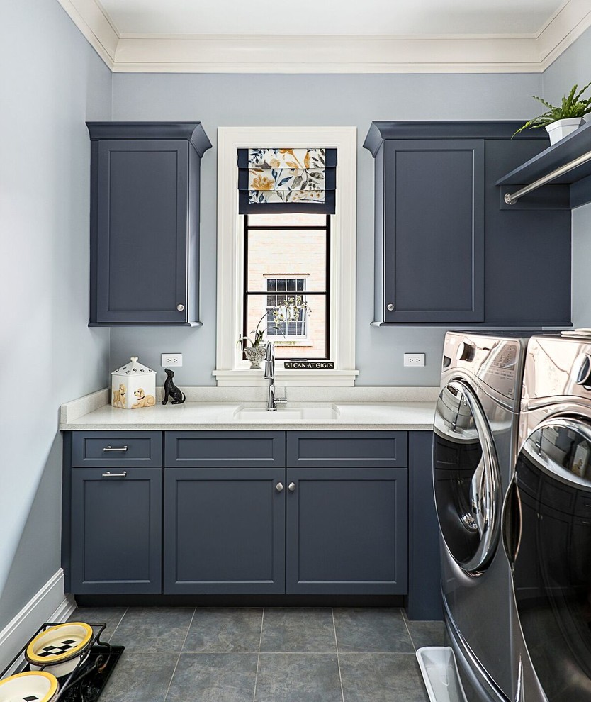 Design ideas for a mid-sized traditional single-wall dedicated laundry room in Chicago with an undermount sink, shaker cabinets, blue cabinets, quartzite benchtops, blue walls, ceramic floors, a side-by-side washer and dryer, grey floor and white benchtop.