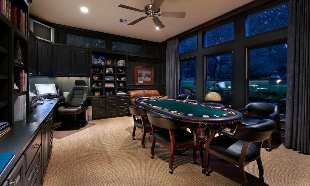 This is an example of a traditional study room in Austin with black walls, carpet and a built-in desk.