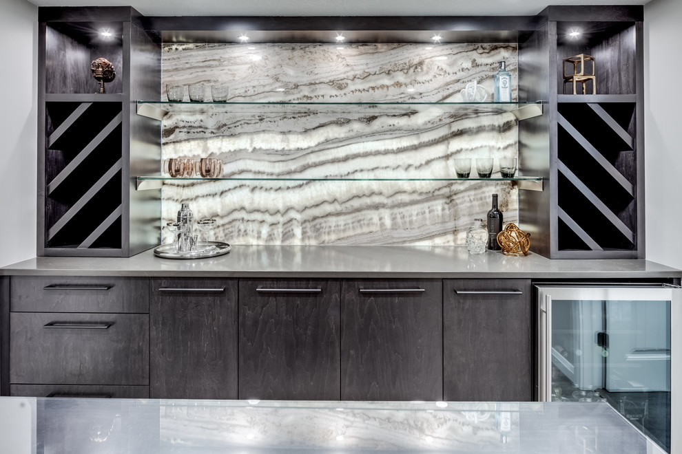 Inspiration for a mid-sized contemporary galley seated home bar in Calgary with no sink, flat-panel cabinets, brown cabinets, quartz benchtops, multi-coloured splashback, stone slab splashback, vinyl floors, grey floor and brown benchtop.