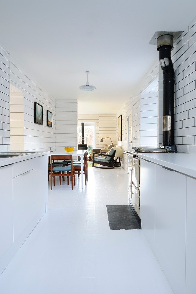 This is an example of a scandinavian kitchen in Other with flat-panel cabinets, white cabinets, white splashback and subway tile splashback.