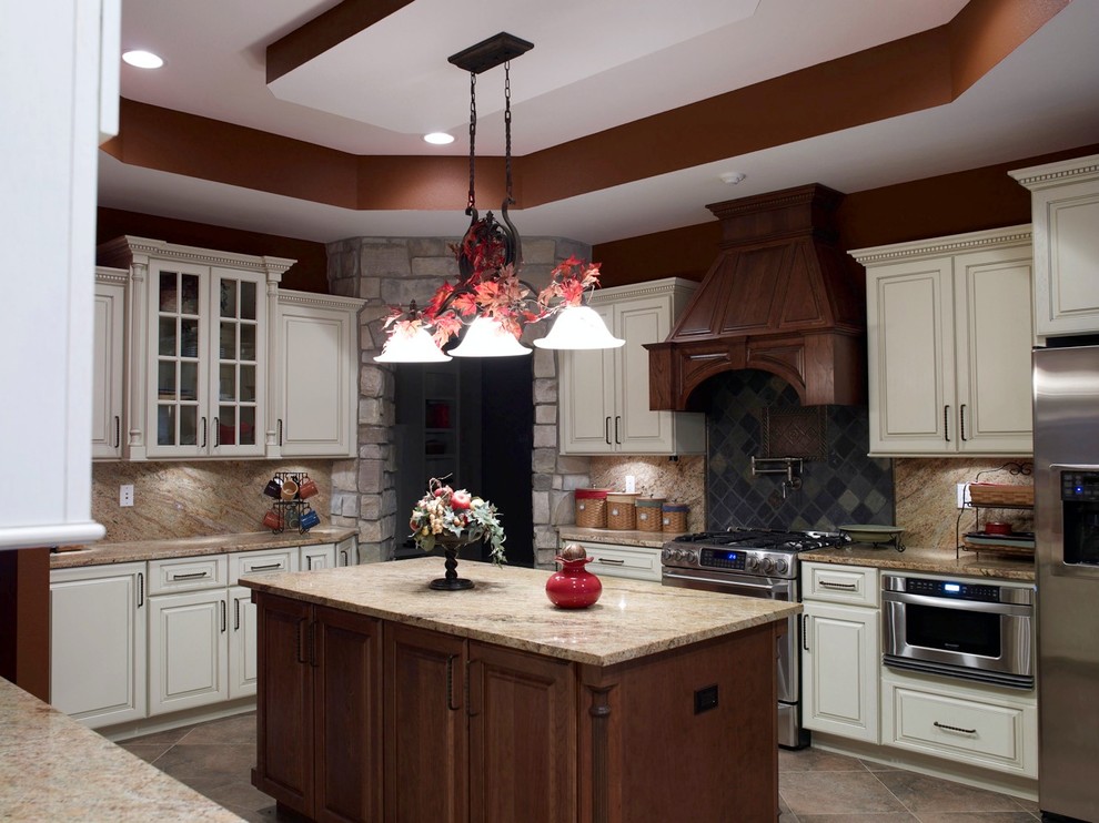 Eat-in kitchen - mid-sized rustic u-shaped eat-in kitchen idea in Cincinnati with raised-panel cabinets, medium tone wood cabinets, white backsplash, stainless steel appliances and an island