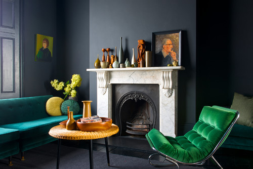 Fauteuil et canapé en velours coloré dans un salon sobre et moderne
