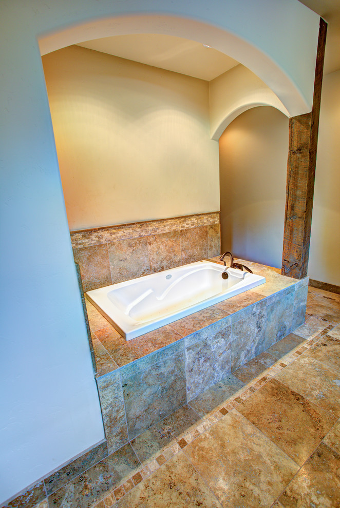 Drop-in bathtub - large rustic master beige tile ceramic tile drop-in bathtub idea with a drop-in sink, raised-panel cabinets, medium tone wood cabinets, a one-piece toilet and white walls
