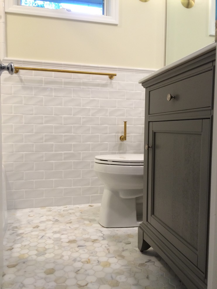 Inspiration for a small traditional bathroom in Kansas City with furniture-like cabinets, grey cabinets, an alcove tub, a one-piece toilet, white tile, subway tile, yellow walls, mosaic tile floors and a console sink.