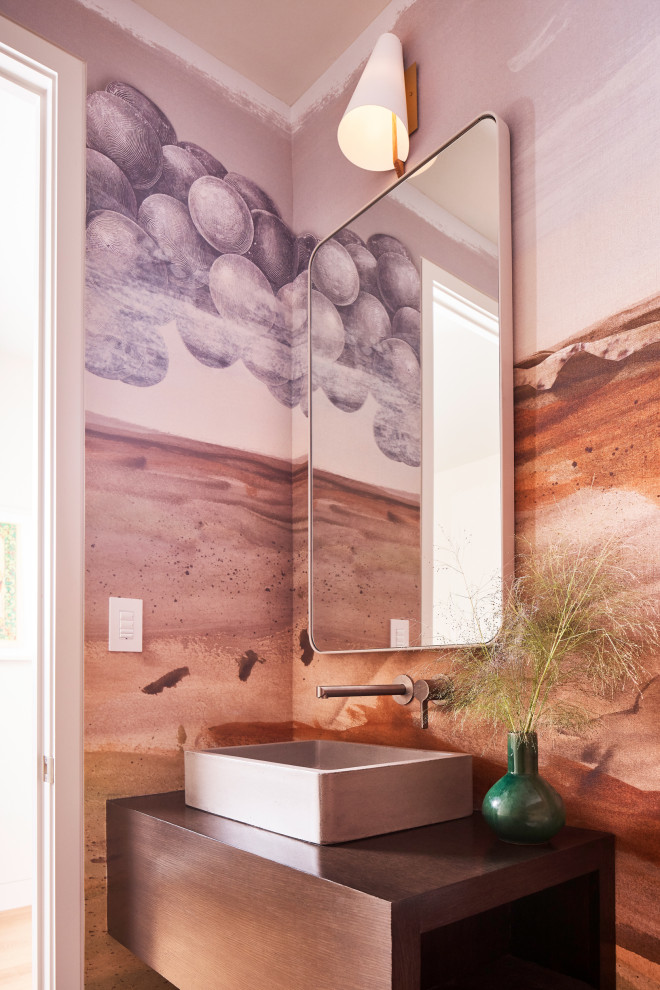 This is an example of a contemporary powder room in Dallas with flat-panel cabinets, dark wood cabinets, multi-coloured walls, a vessel sink, wood benchtops, brown benchtops, a floating vanity and wallpaper.