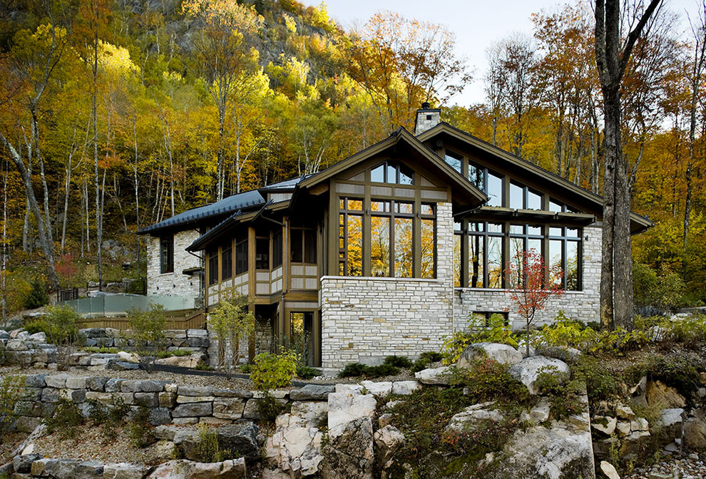 This is an example of a large country exterior in Other with stone veneer and a gable roof.